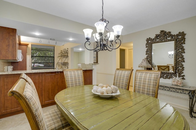 tiled dining space with a notable chandelier