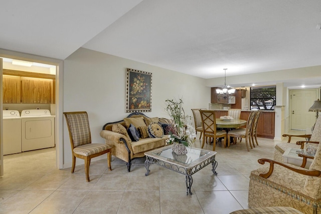 living room featuring a chandelier, light tile patterned floors, and washing machine and clothes dryer