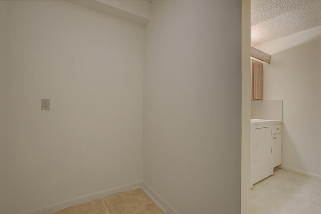 laundry room featuring washer / dryer, a textured ceiling, and light tile patterned floors