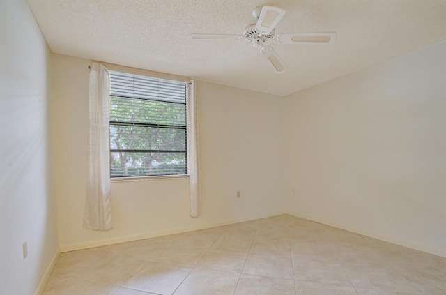 tiled empty room featuring ceiling fan and a textured ceiling