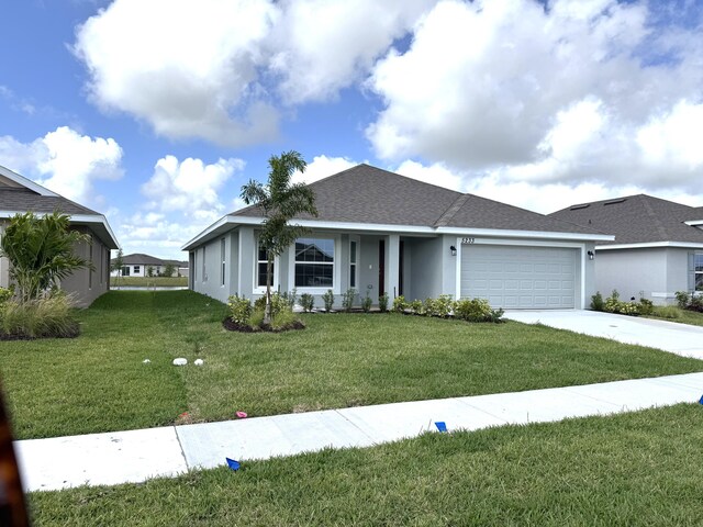 ranch-style home featuring a front lawn and a garage