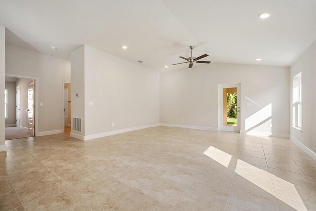 spare room with ceiling fan, light tile patterned floors, a wealth of natural light, and vaulted ceiling