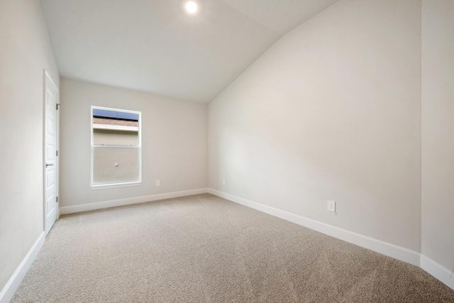 carpeted spare room featuring lofted ceiling