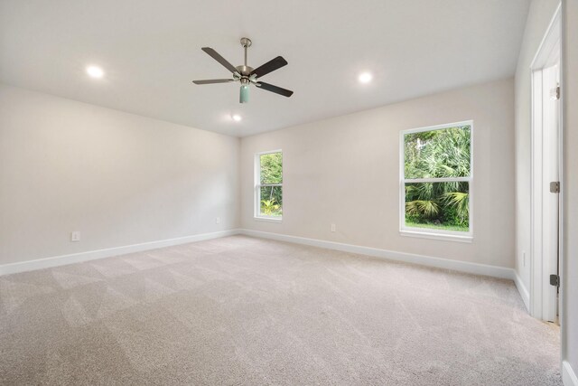 spare room with ceiling fan and light colored carpet