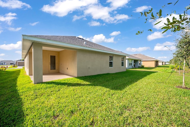 back of property featuring a lawn and a patio