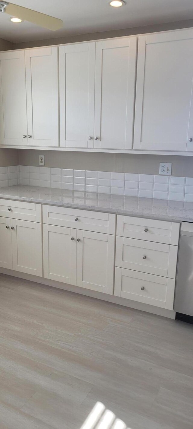 kitchen featuring appliances with stainless steel finishes, sink, white cabinets, and light wood-type flooring