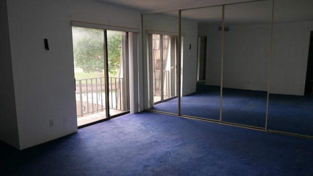 unfurnished bedroom with access to exterior, carpet floors, and a closet