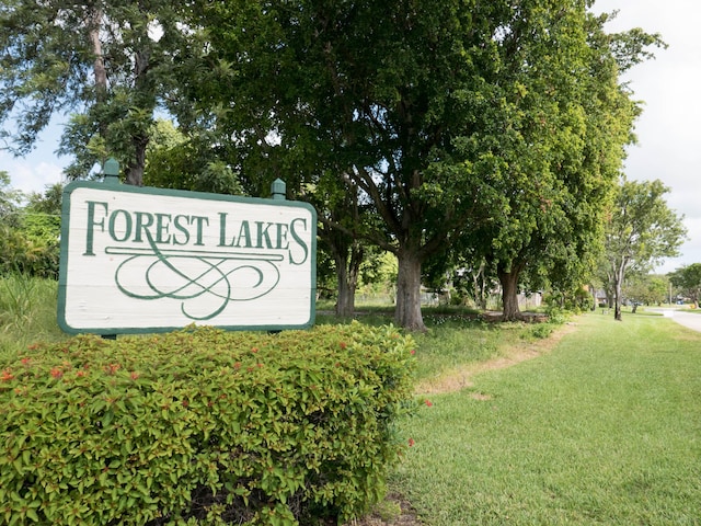 community / neighborhood sign featuring a lawn