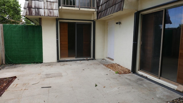 view of exterior entry with a patio