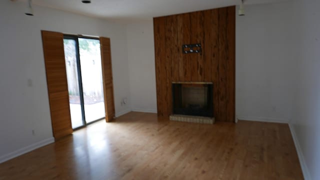 unfurnished living room featuring a fireplace and light hardwood / wood-style flooring