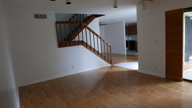 empty room with ceiling fan and light wood-type flooring