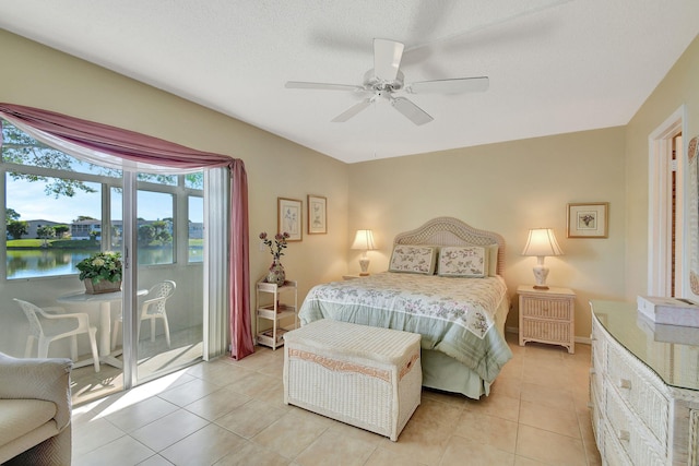 tiled bedroom featuring ceiling fan, a water view, a textured ceiling, and access to outside