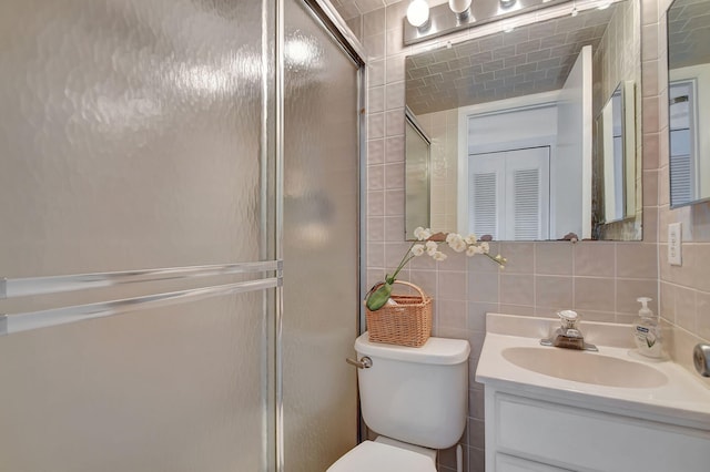 bathroom with backsplash, an enclosed shower, vanity, tile walls, and toilet