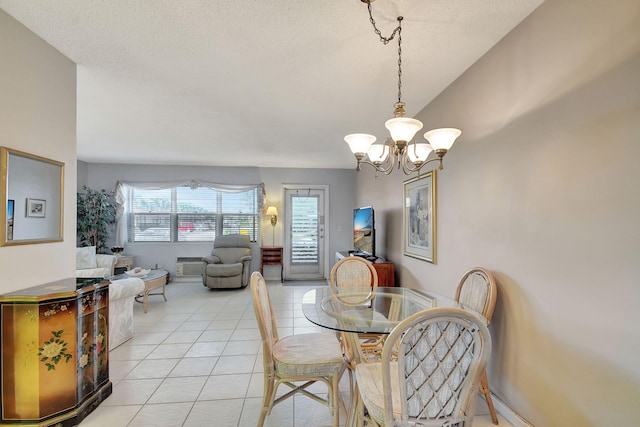 dining area featuring light tile patterned flooring, a chandelier, and a textured ceiling