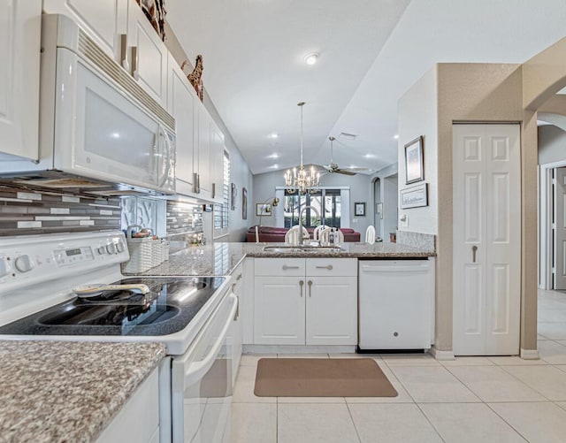 kitchen with white appliances, vaulted ceiling, ceiling fan, sink, and white cabinets