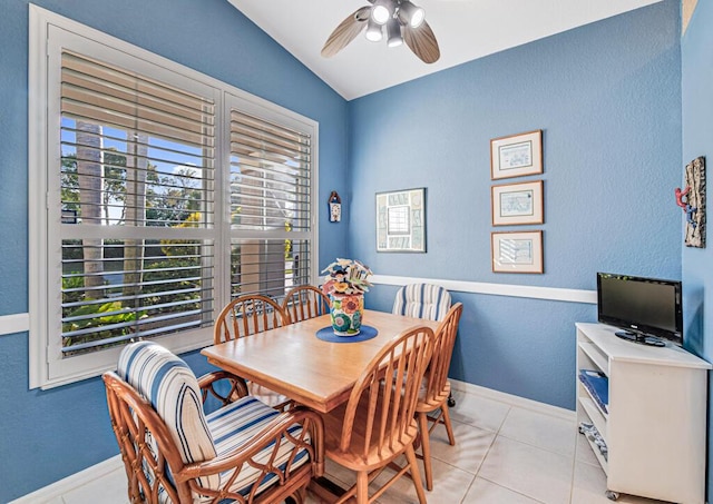 tiled dining room featuring ceiling fan and vaulted ceiling