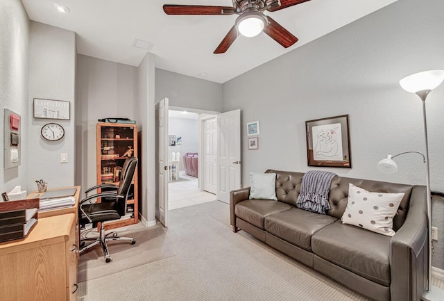 carpeted home office featuring ceiling fan