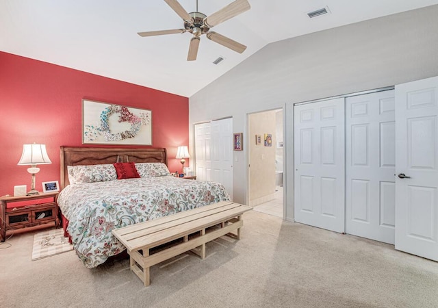 bedroom featuring ceiling fan, high vaulted ceiling, light colored carpet, and two closets