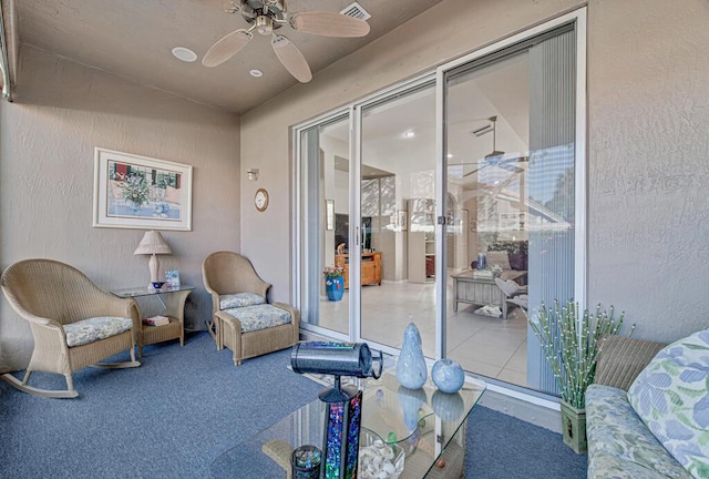 living area with carpet flooring and ceiling fan