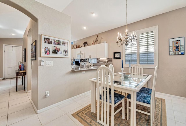 tiled dining room with sink, lofted ceiling, and a notable chandelier