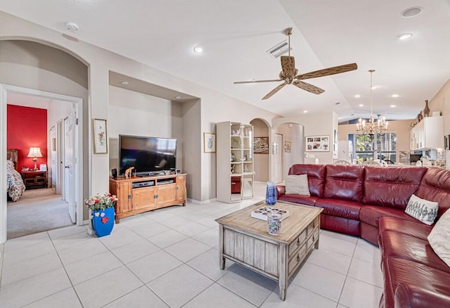 tiled living room with ceiling fan with notable chandelier and vaulted ceiling