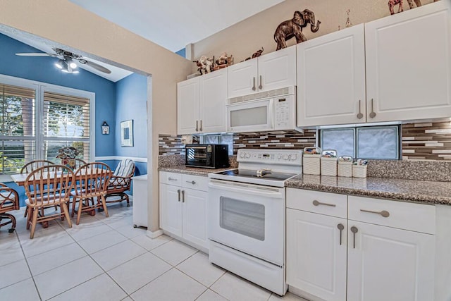 kitchen with tasteful backsplash, white cabinets, lofted ceiling, white appliances, and light tile patterned floors