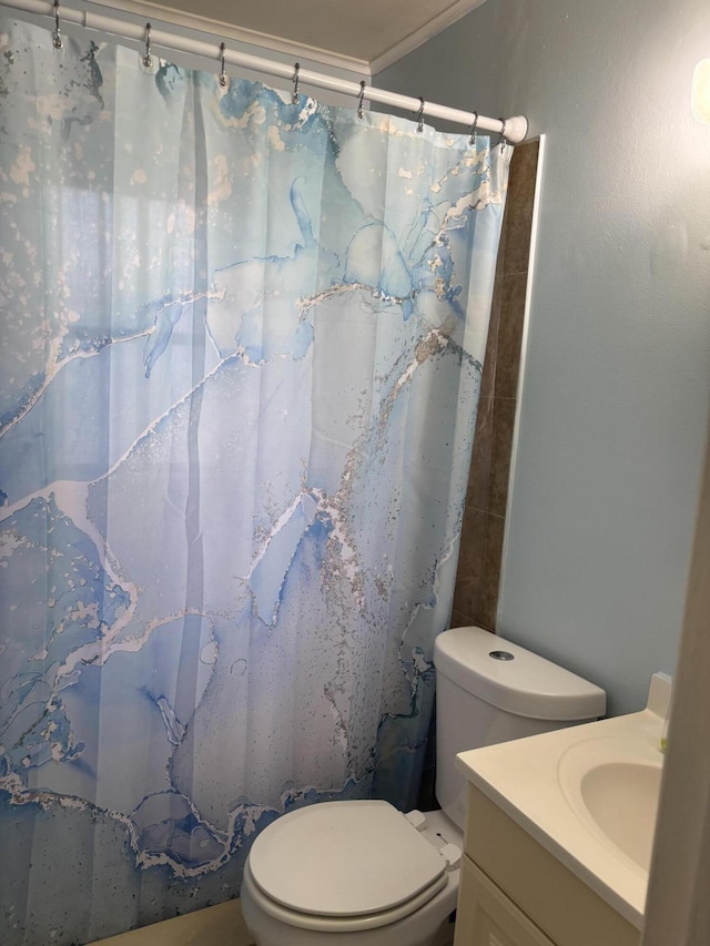 bathroom with vanity, toilet, and crown molding