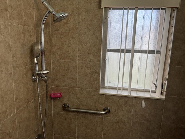 interior details featuring a tile shower