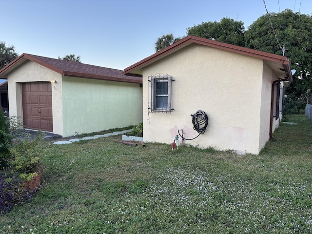 view of side of property featuring a garage and a yard