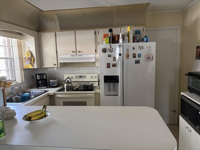 kitchen featuring stainless steel electric range oven, white fridge with ice dispenser, sink, backsplash, and white cabinets