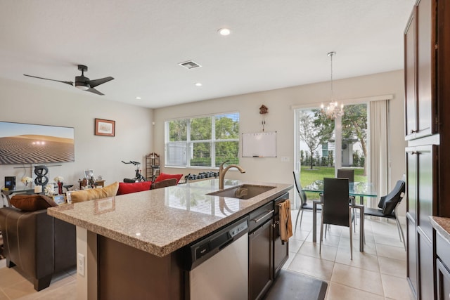 kitchen featuring dishwasher, a kitchen island with sink, ceiling fan with notable chandelier, hanging light fixtures, and sink