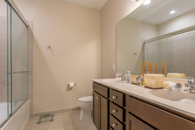 full bathroom with shower / bath combination with glass door, tile patterned flooring, vanity, and toilet