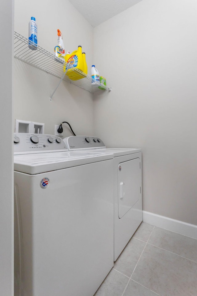 laundry room with light tile patterned flooring and washing machine and dryer