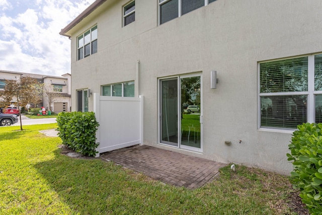 rear view of property featuring a lawn and a patio