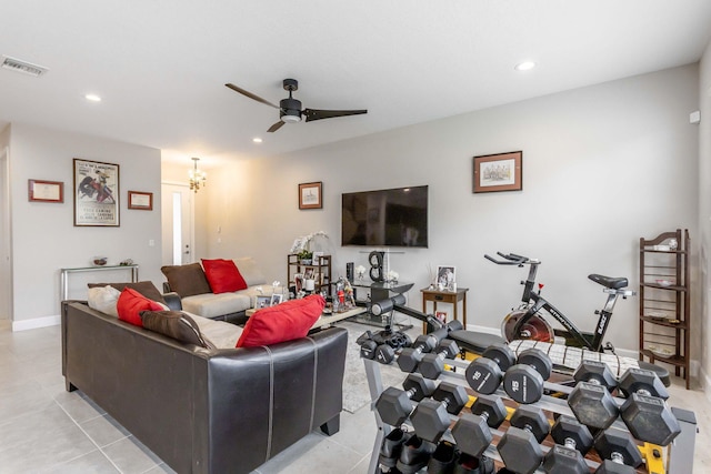 tiled living room featuring ceiling fan with notable chandelier