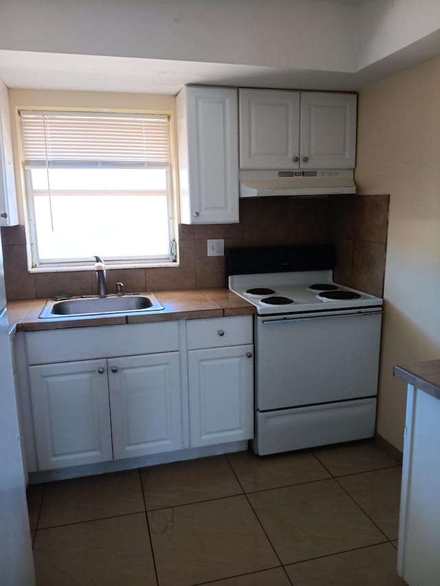 kitchen with backsplash, exhaust hood, sink, electric stove, and white cabinets