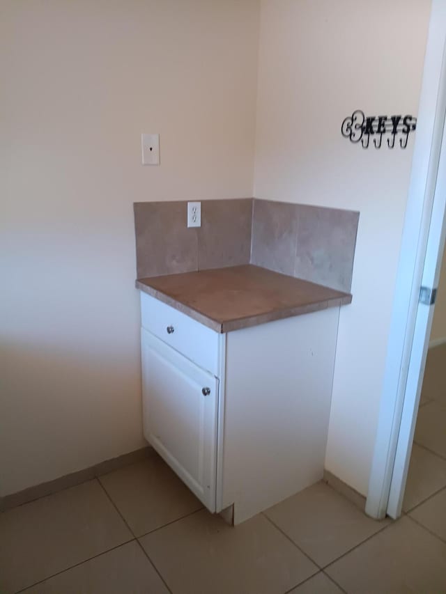 kitchen with white cabinets, tasteful backsplash, and light tile patterned flooring