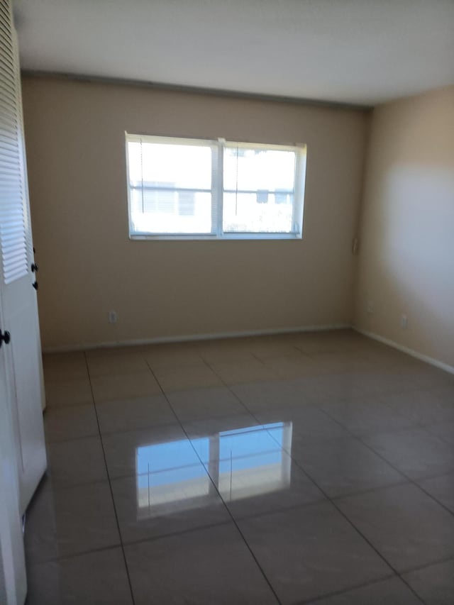 tiled spare room with a healthy amount of sunlight