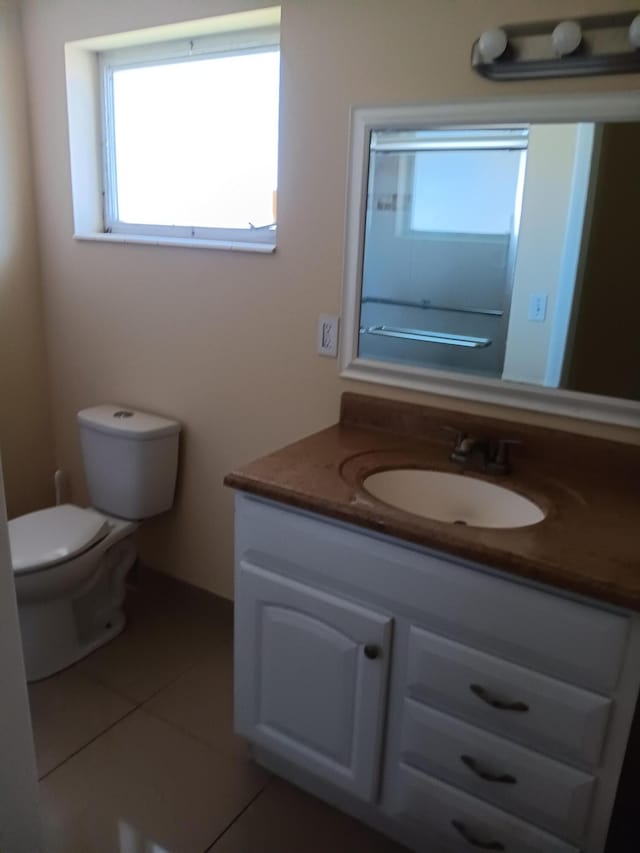 bathroom featuring tile patterned flooring, vanity, and toilet