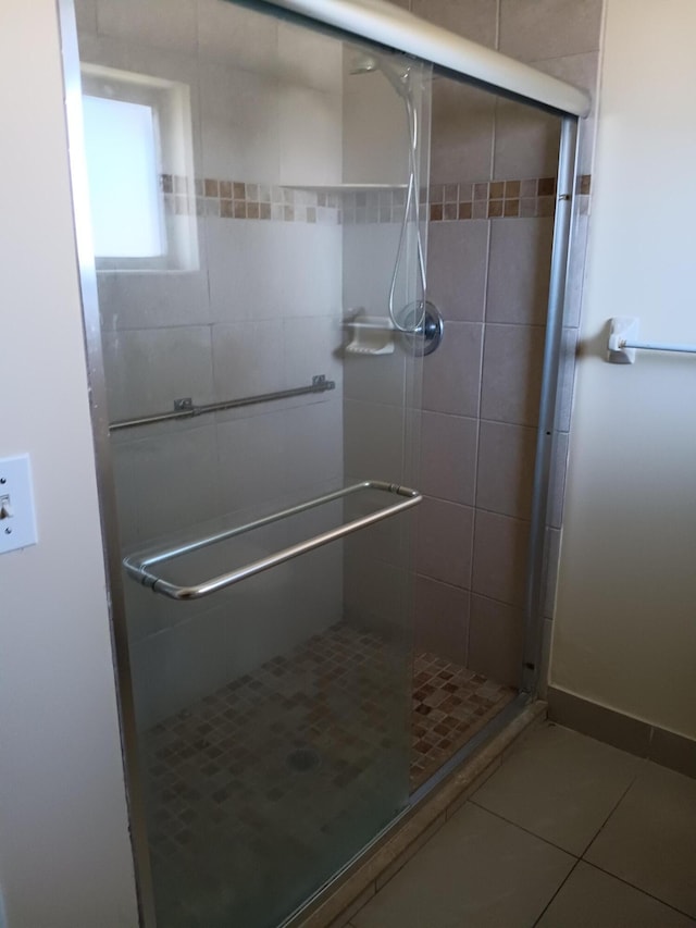 bathroom with tile patterned flooring and a shower with shower door