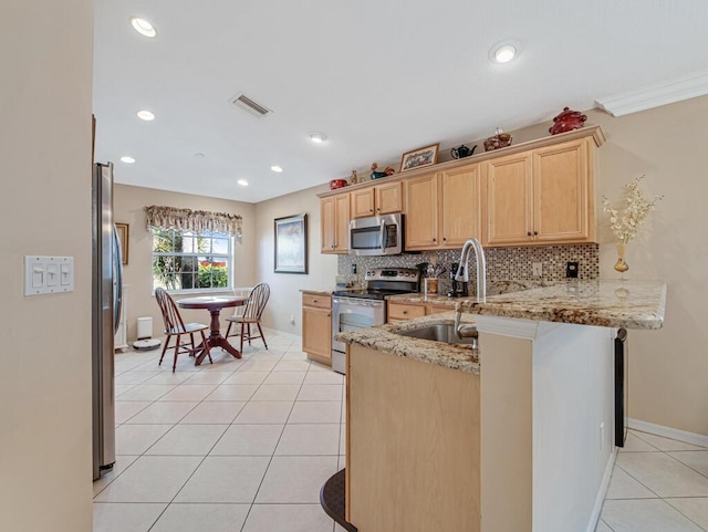 kitchen with kitchen peninsula, light stone counters, stainless steel appliances, light tile patterned floors, and light brown cabinets