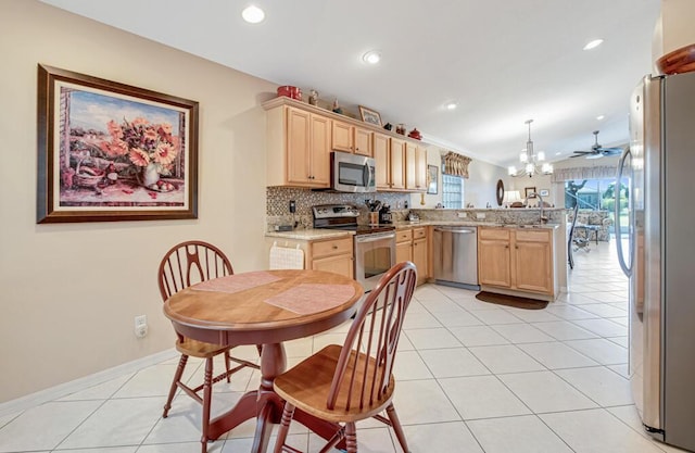 kitchen with kitchen peninsula, appliances with stainless steel finishes, light brown cabinetry, pendant lighting, and light tile patterned flooring