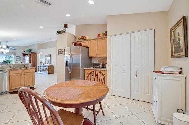 kitchen with light brown cabinetry, stainless steel appliances, and light tile patterned floors