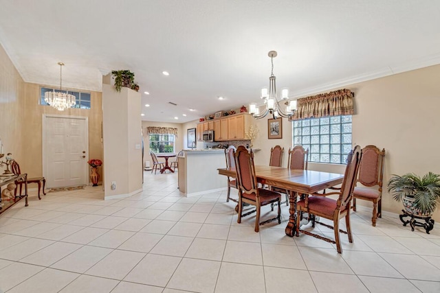 dining area with light tile patterned floors, a chandelier, and ornamental molding