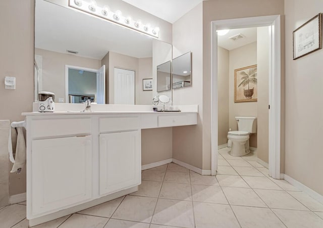 bathroom with tile patterned flooring, vanity, and toilet