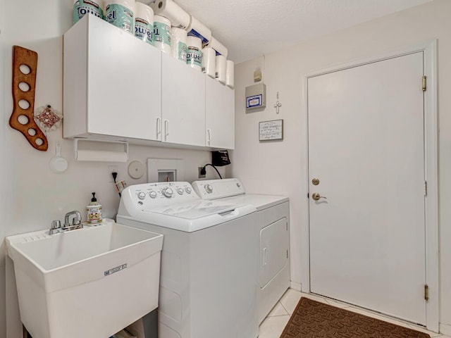 clothes washing area with separate washer and dryer, sink, light tile patterned floors, and cabinets