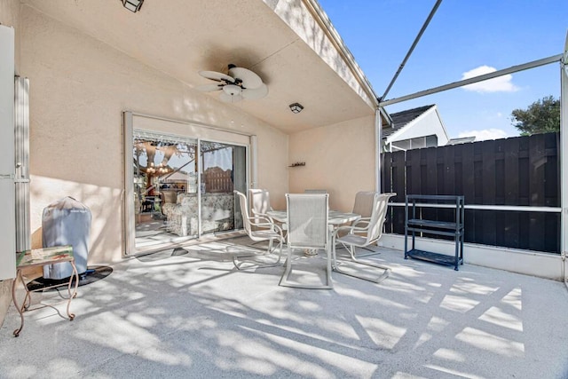 view of patio featuring glass enclosure and ceiling fan