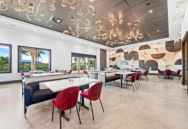 dining room with a raised ceiling and a drop ceiling