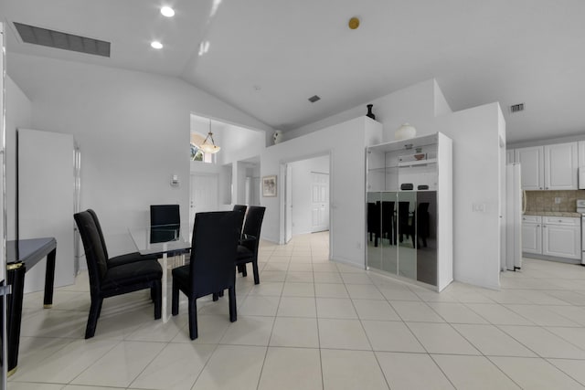 dining space featuring light tile patterned floors, vaulted ceiling, and a chandelier