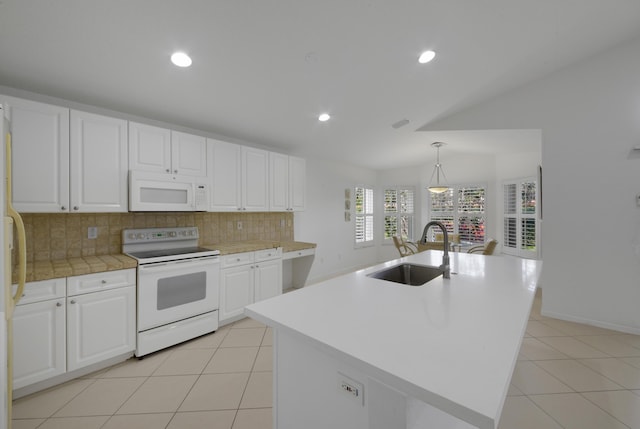 kitchen featuring a center island with sink, decorative light fixtures, white appliances, white cabinets, and sink